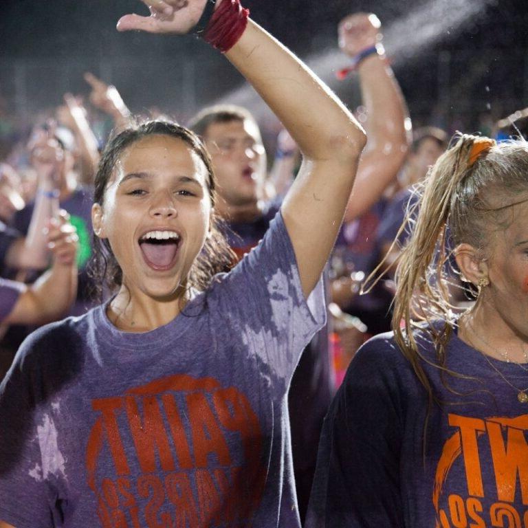 Female student cheering at paint wars.